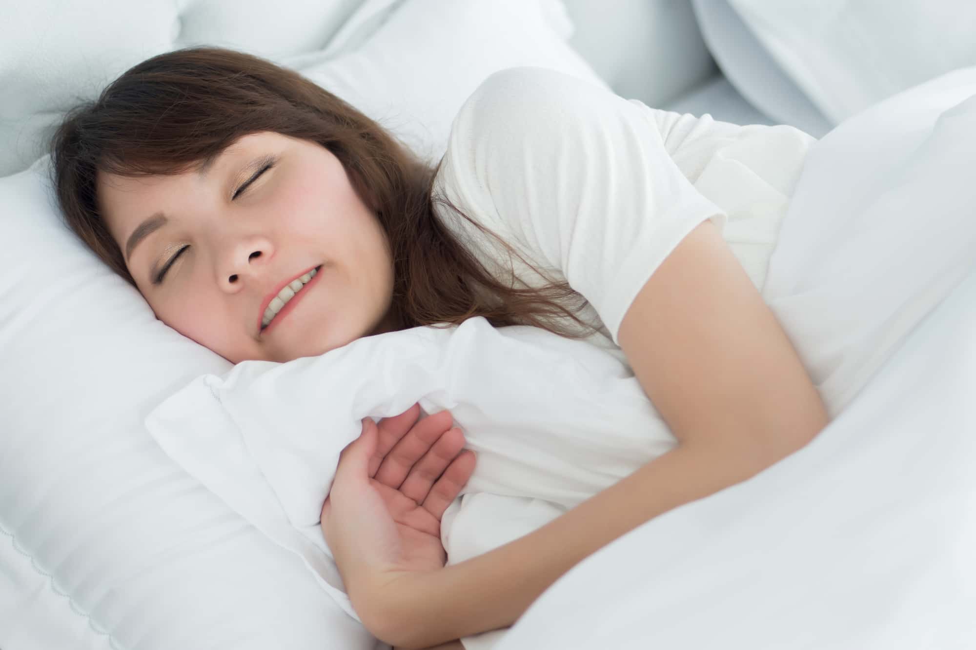 顎関節症の原因となる睡眠中に歯ぎしりをする女性
