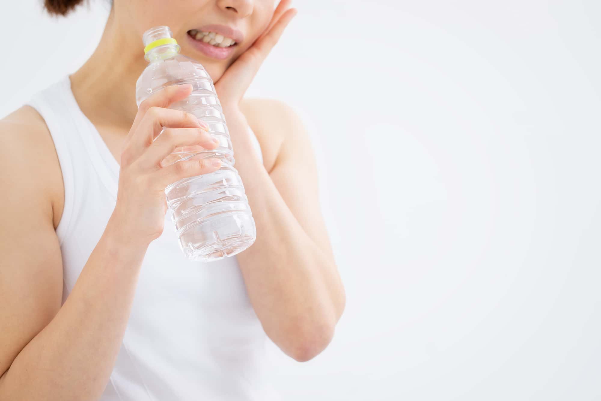 歯のクリーニング直後に冷たい水がしみる女性