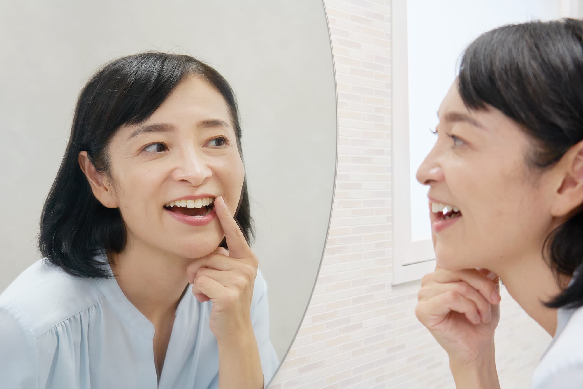 白くなった歯を鏡で確認する女性