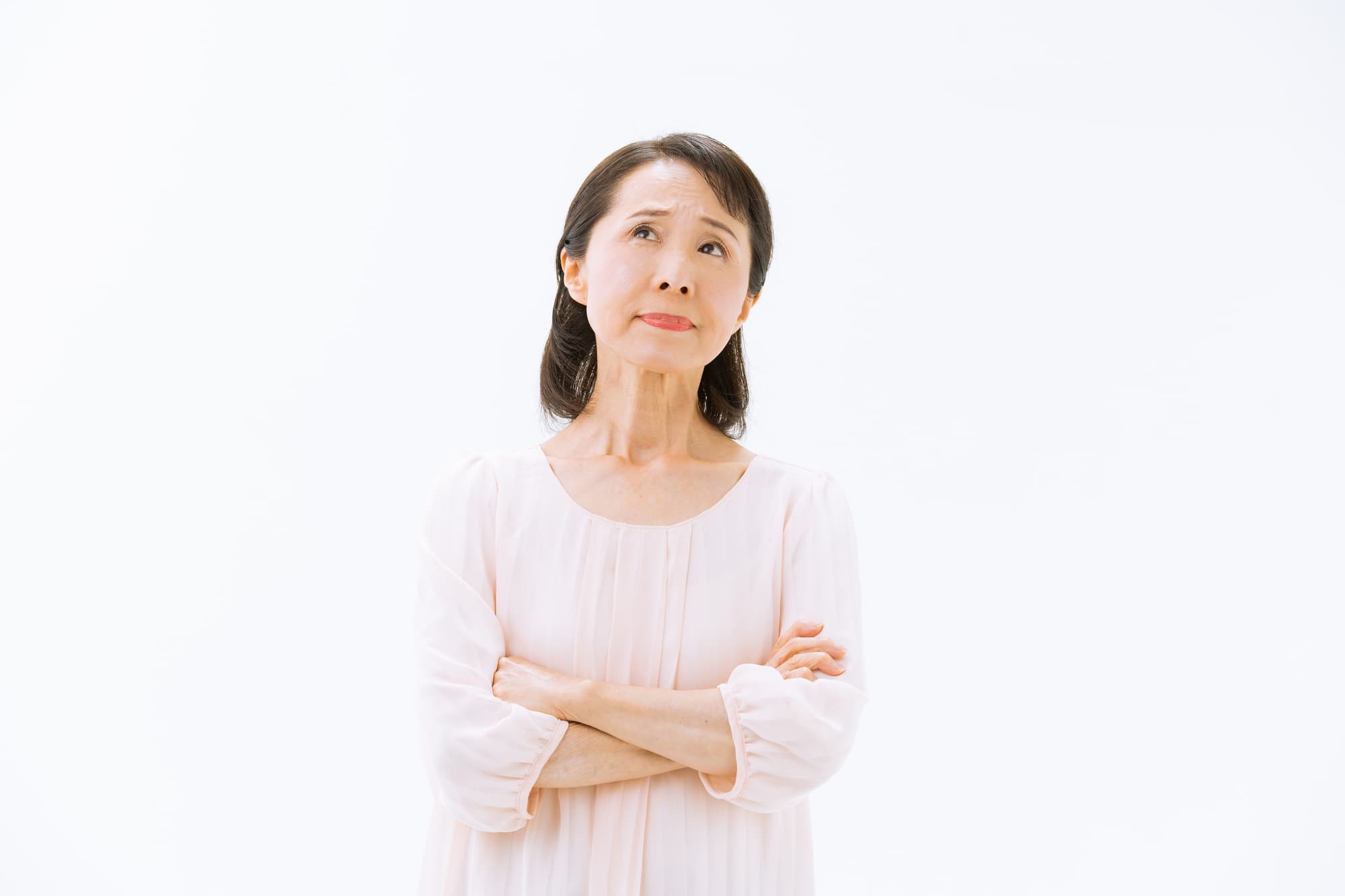 入れ歯が合わない原因を腕組みし考える女性