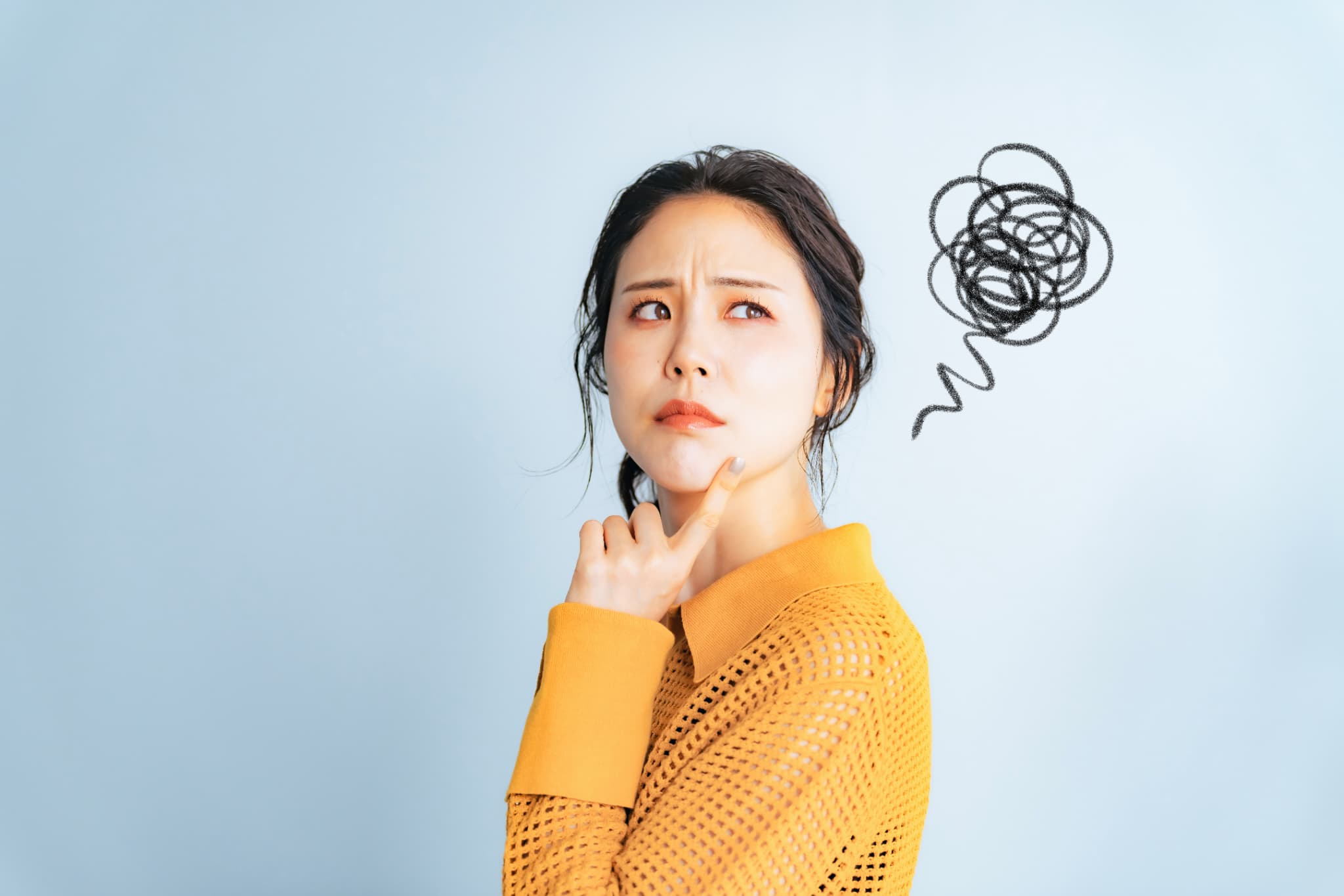 悩む黄色い服の女性