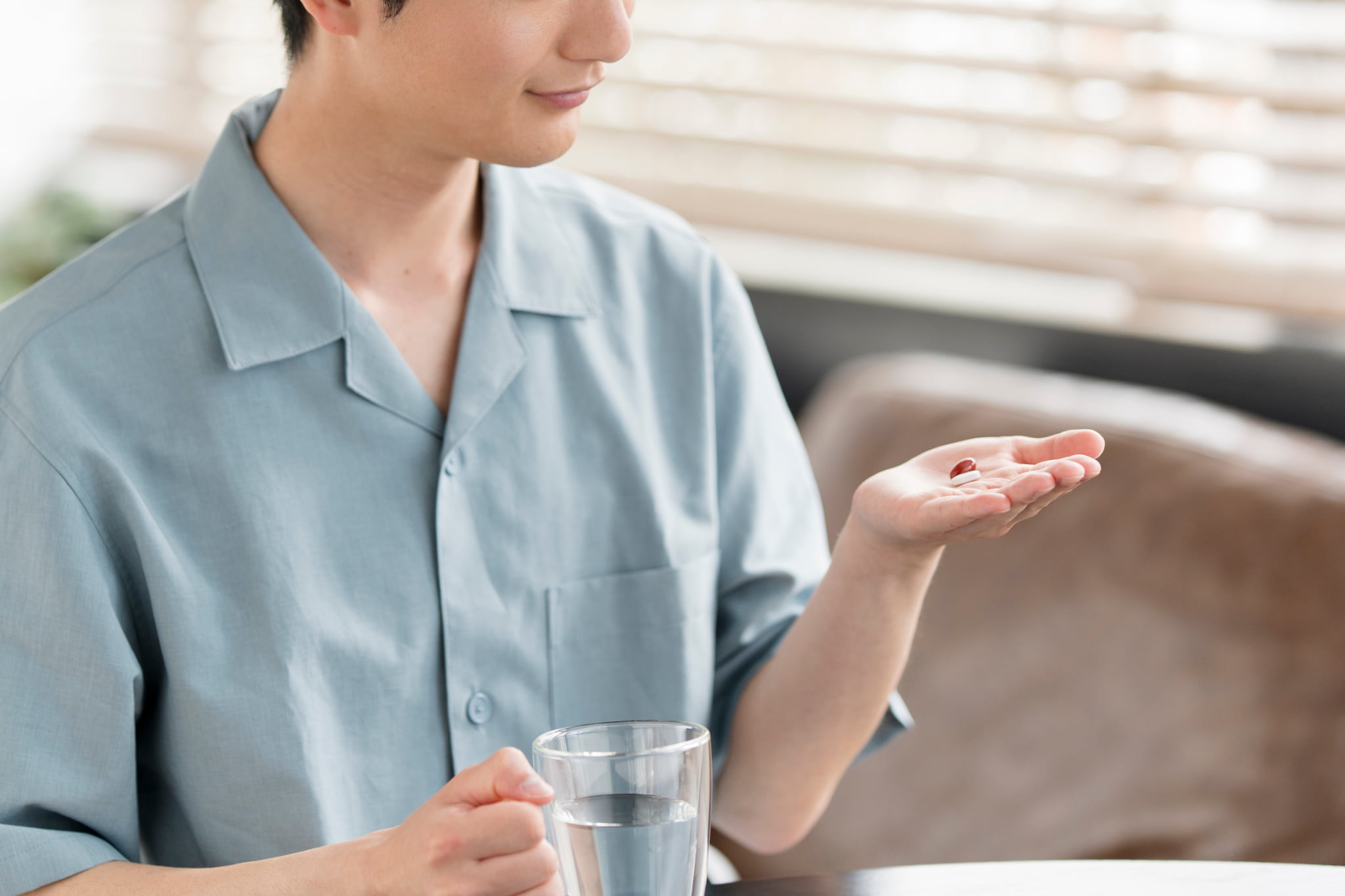 親知らずを抜歯したあと痛み止めを服用する男性