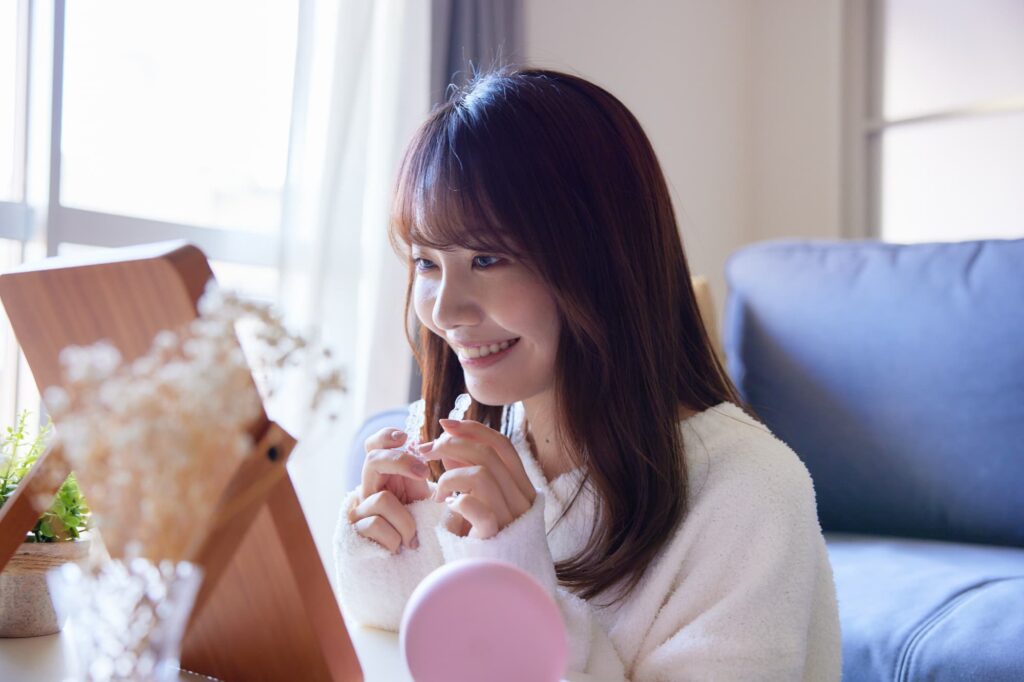 マウスピース矯正の装置を装着しようとしている女性
